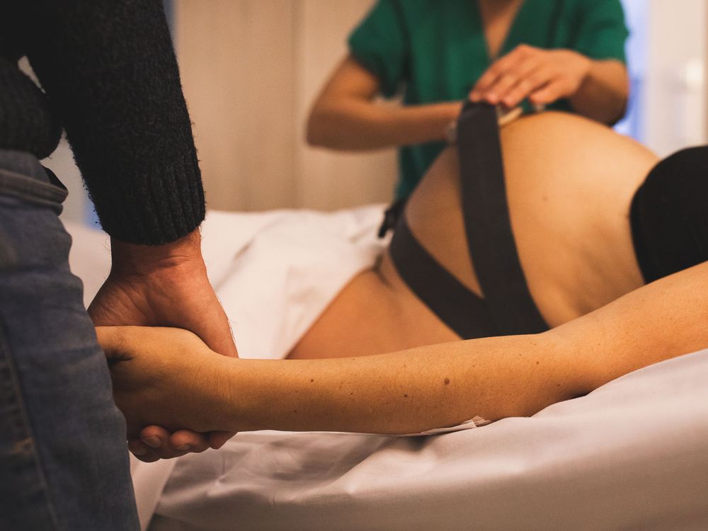 Healthcare providers performing a medical procedure on a patient in a clinical setting.
