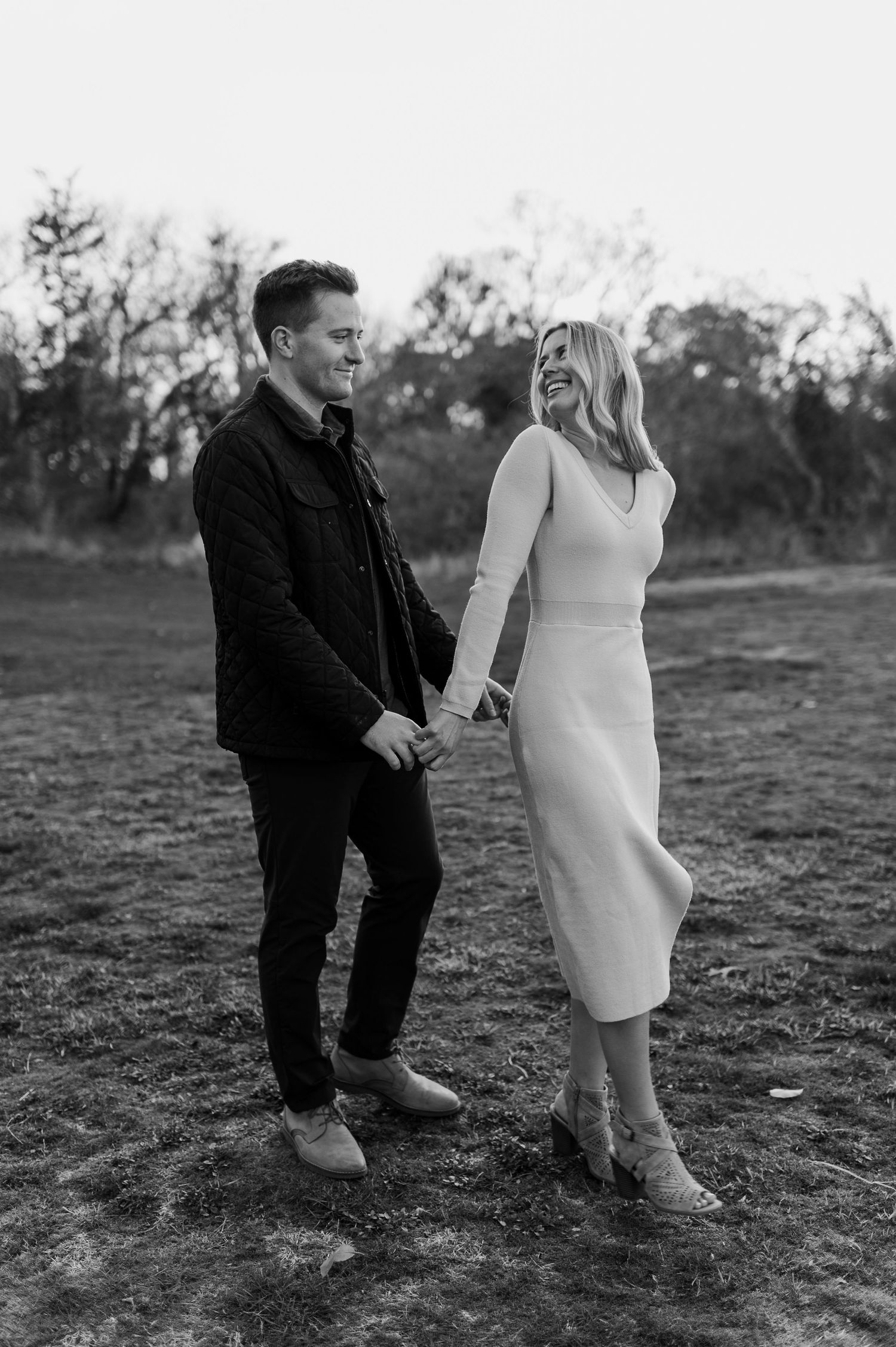 Couple sharing playful moment in casual attire outdoors.