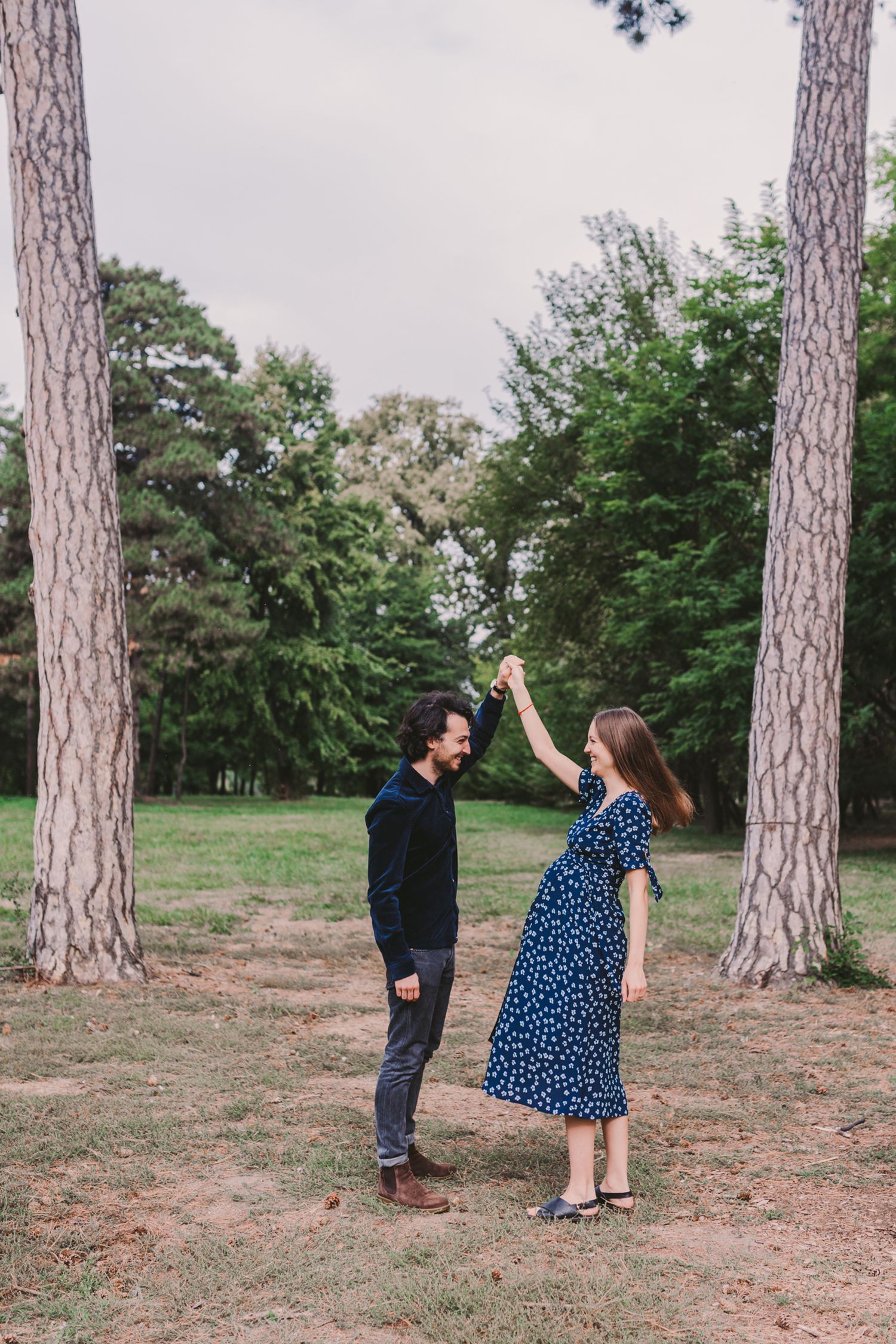 A couple plays a fun game near tall pine trees in a natural setting.