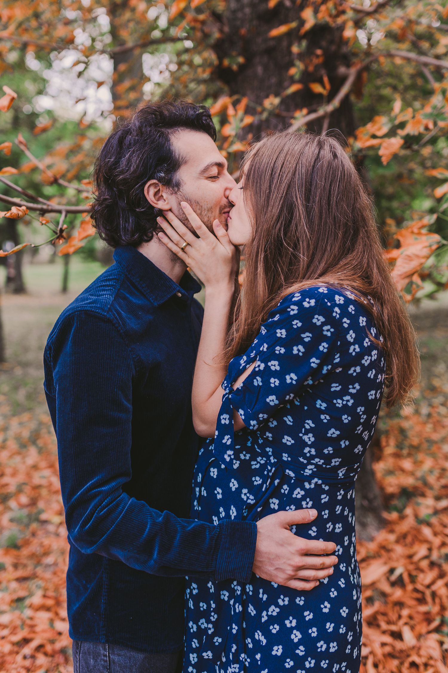 A tender embrace between a couple surrounded by fall foliage.