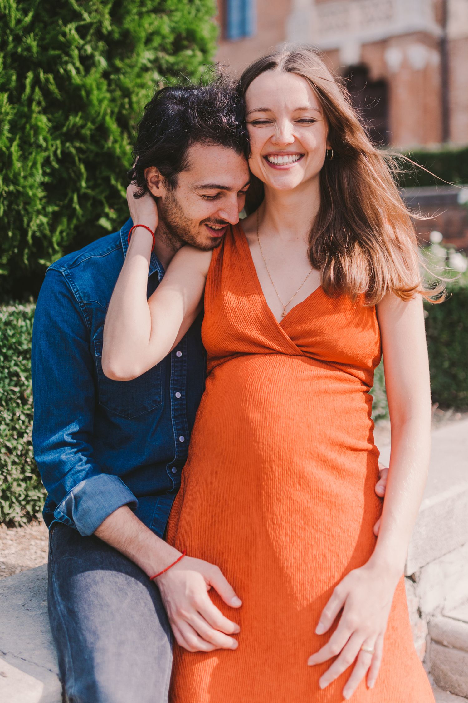 Romantic maternity photos capture couple's joy as they embrace outdoors.