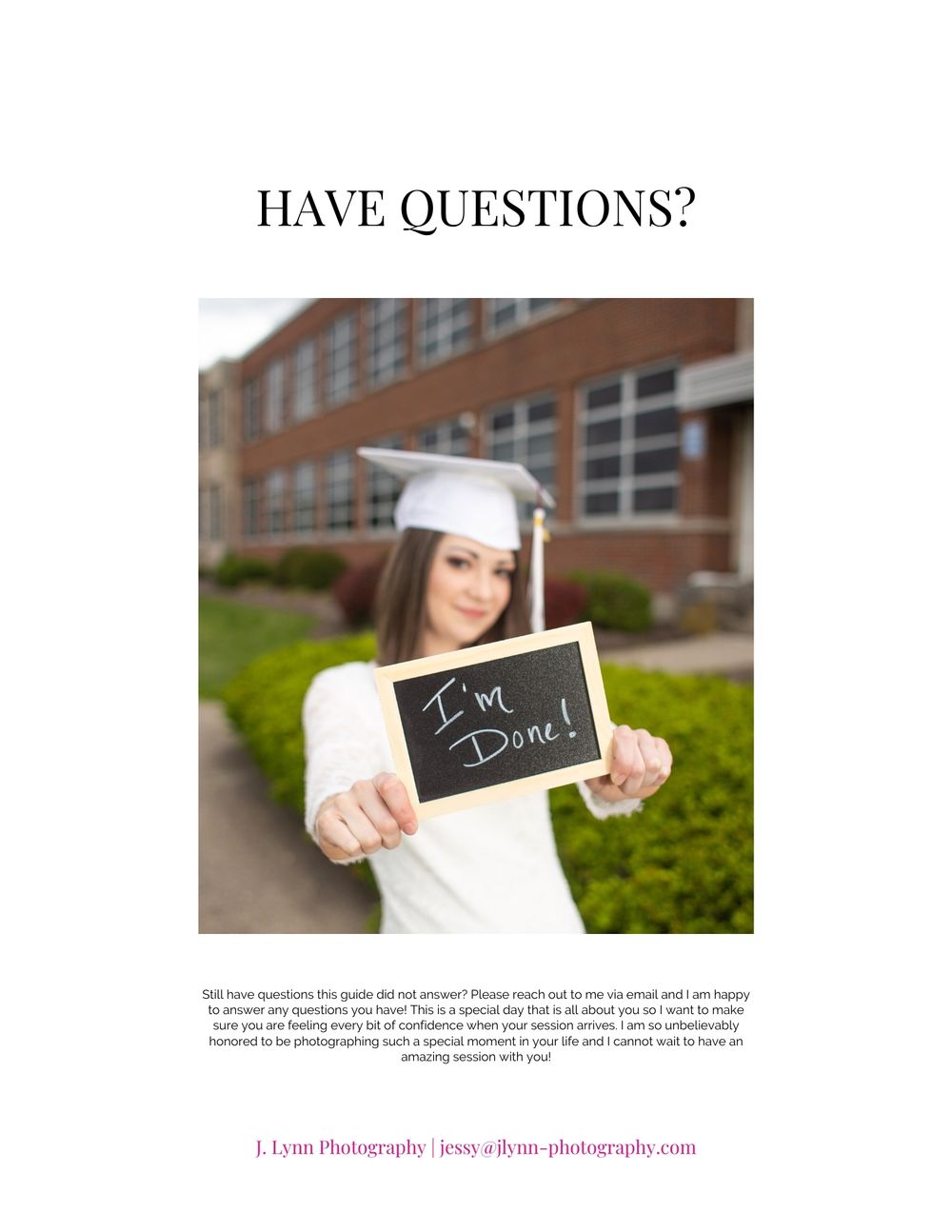 Graduate holding small chalkboard in front of brick building.