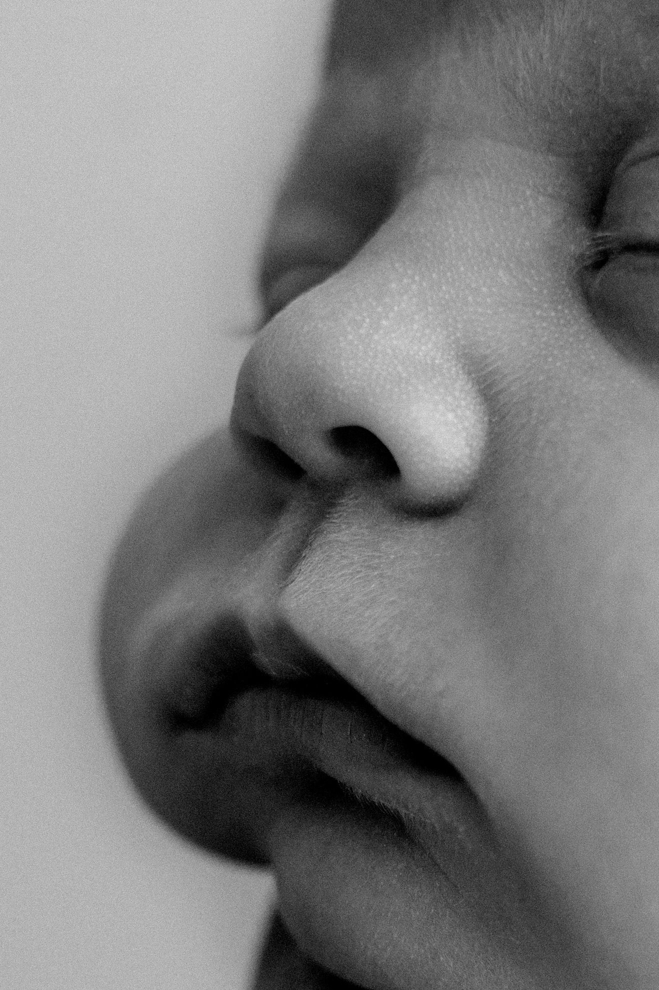 Close-up black and white portrait showing nose and lips in soft natural light.