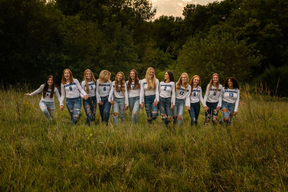 Group photo lineup in a grassy field with everyone wearing matching casual attire.