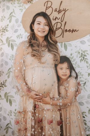 Baby shower photos with floral backdrop and sign reading Baby Bloom.