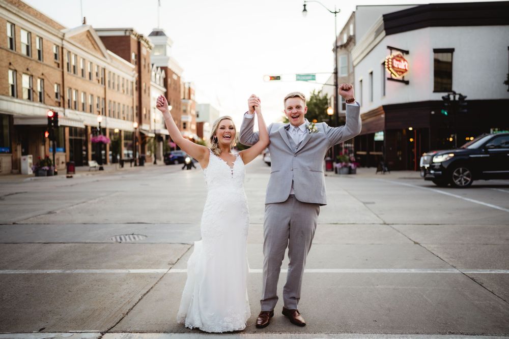 Celebratory moment of newlyweds on city street with historic buildings.