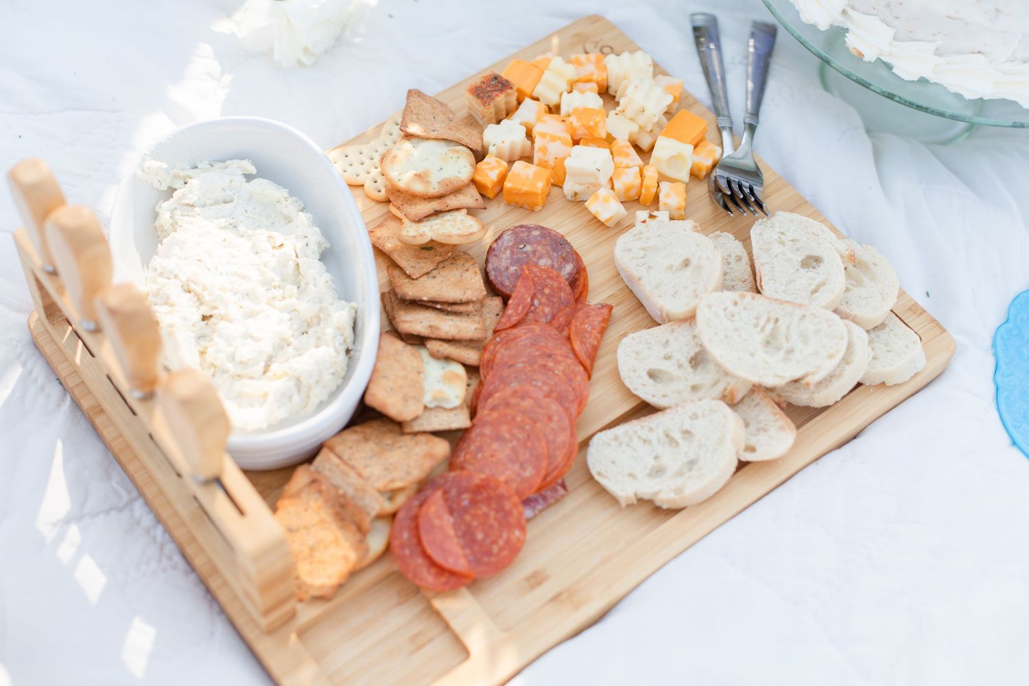 Charcuterie board with meats, cheeses and crackers arranged on a wooden serving platter.