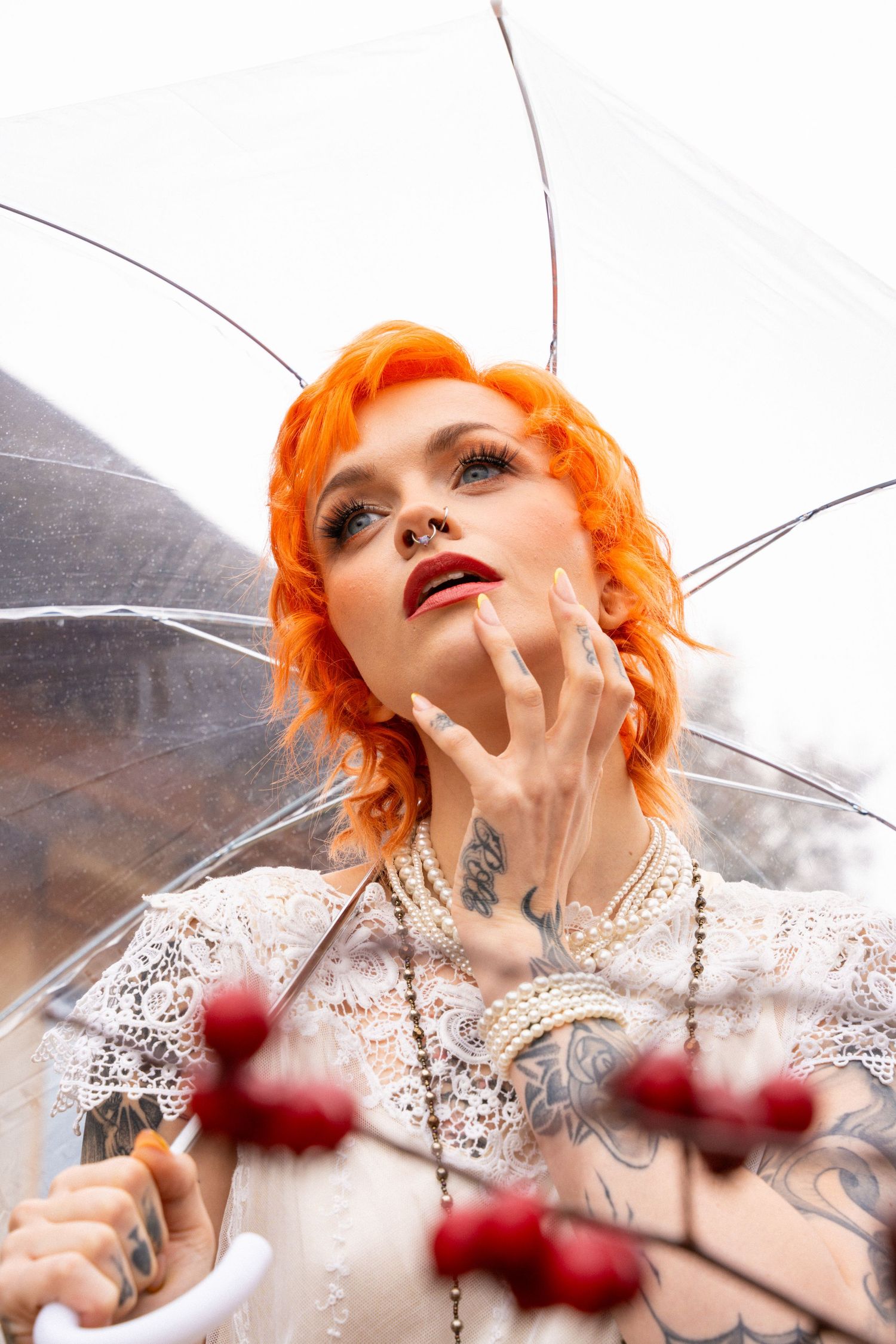 Artistic portrait series with white lace and pearls against transparent umbrella backdrop.