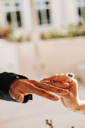 Close-up shot of hands during a ring exchange ceremony.