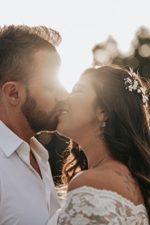 A tender intimate moment between newlyweds captured in beautiful sunlit photography.