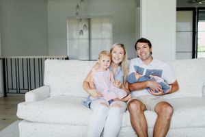 Family relaxing together on a comfortable white couch in a bright modern living room.