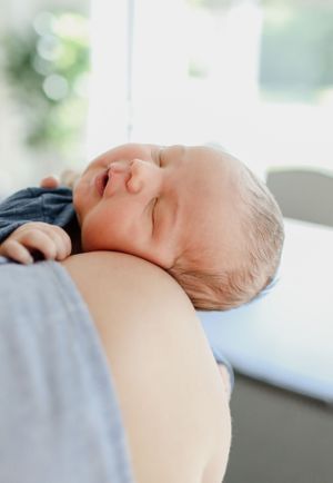 Sleeping newborn baby resting peacefully on soft bedding.