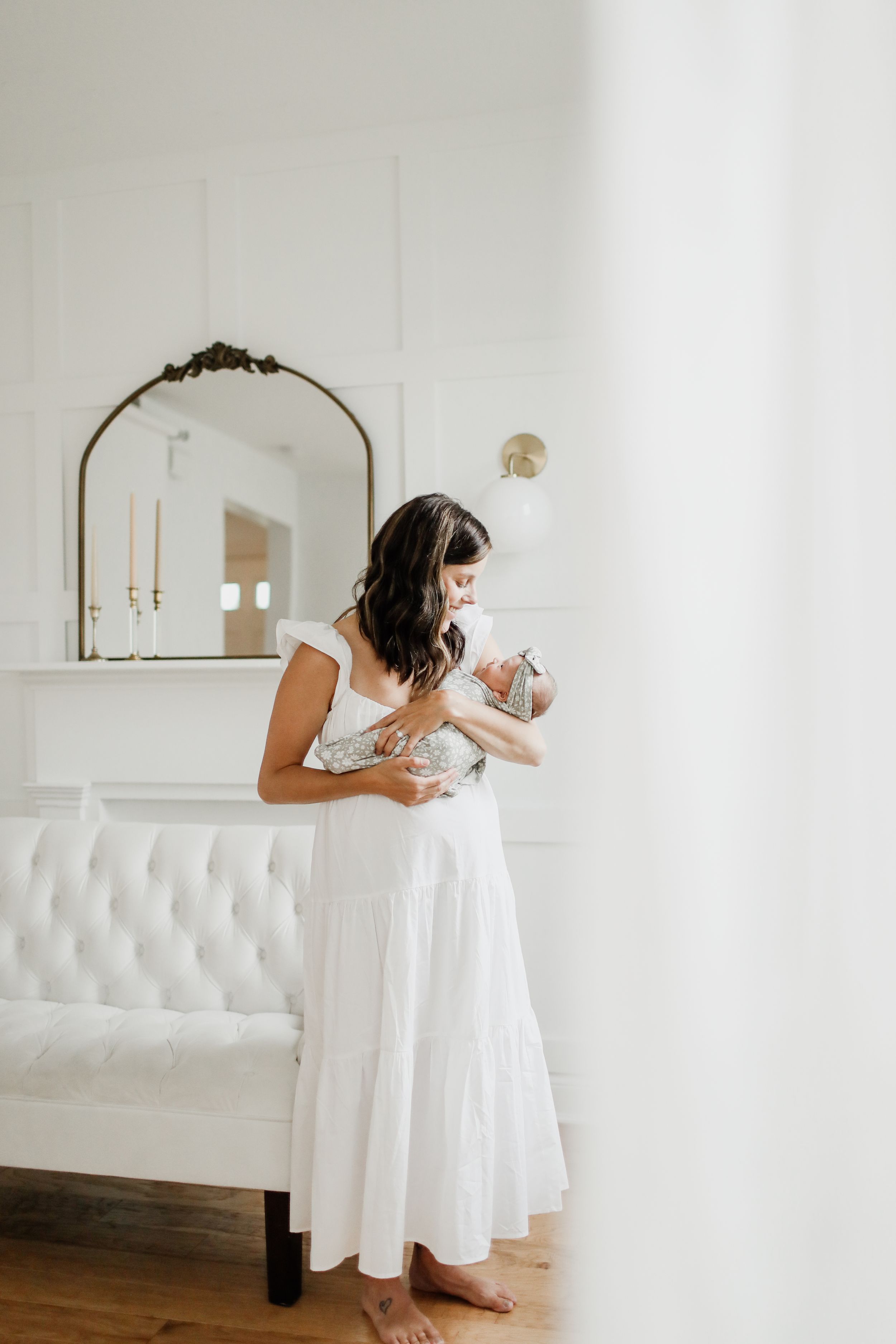 Woman in white dress dancing and twirling in a bright minimalist room.