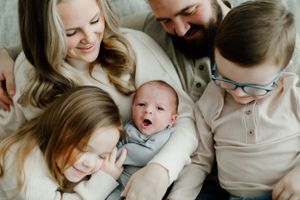 Intimate family portrait series showing tender moments between parents and baby on a light background.