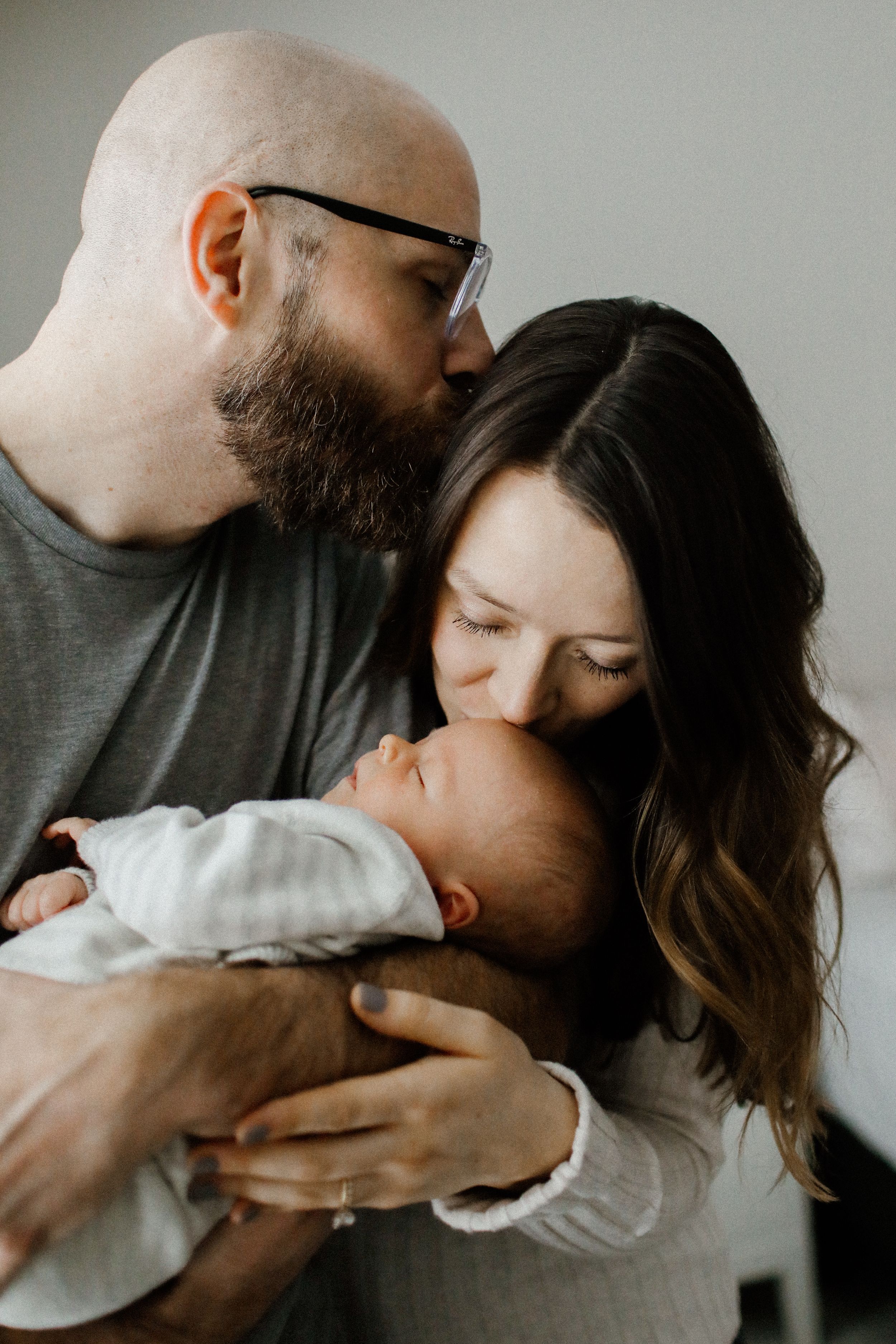 Intimate series of a couple sharing tender moments against a neutral grey background.