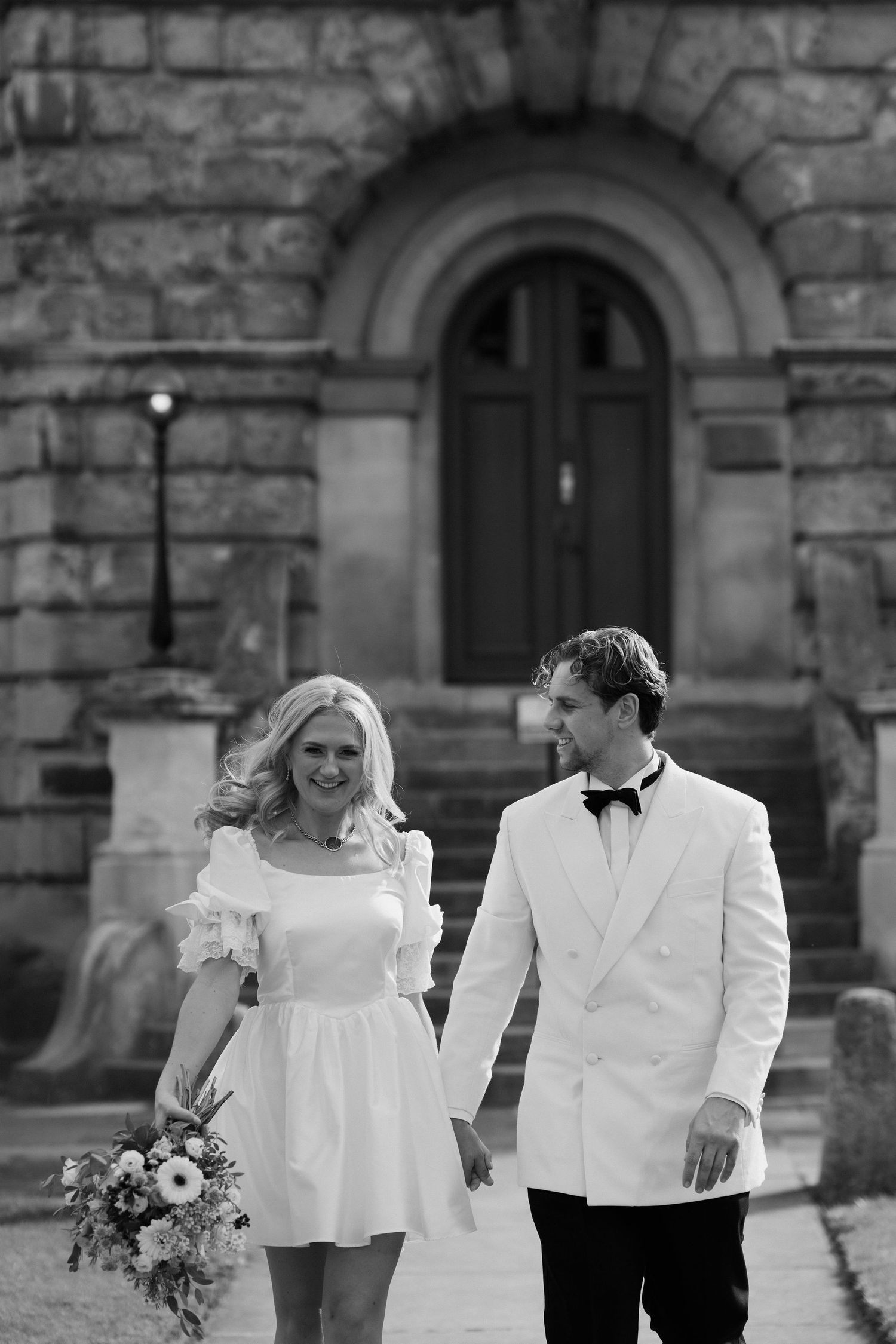 bride and groom walking outside the bodleian library in Oxford
