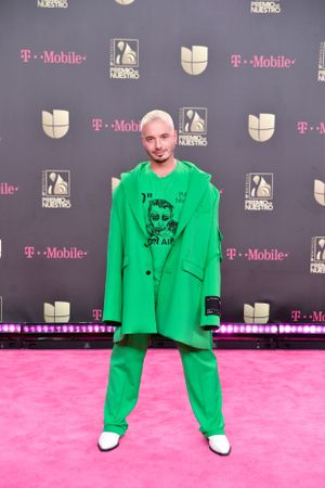 Bold bright green oversized suit ensemble on pink carpet at T-Mobile event.
