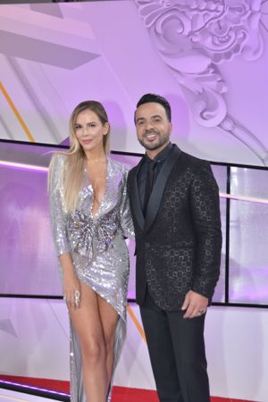 Elegant couple in formal attire pose together at entertainment industry event.