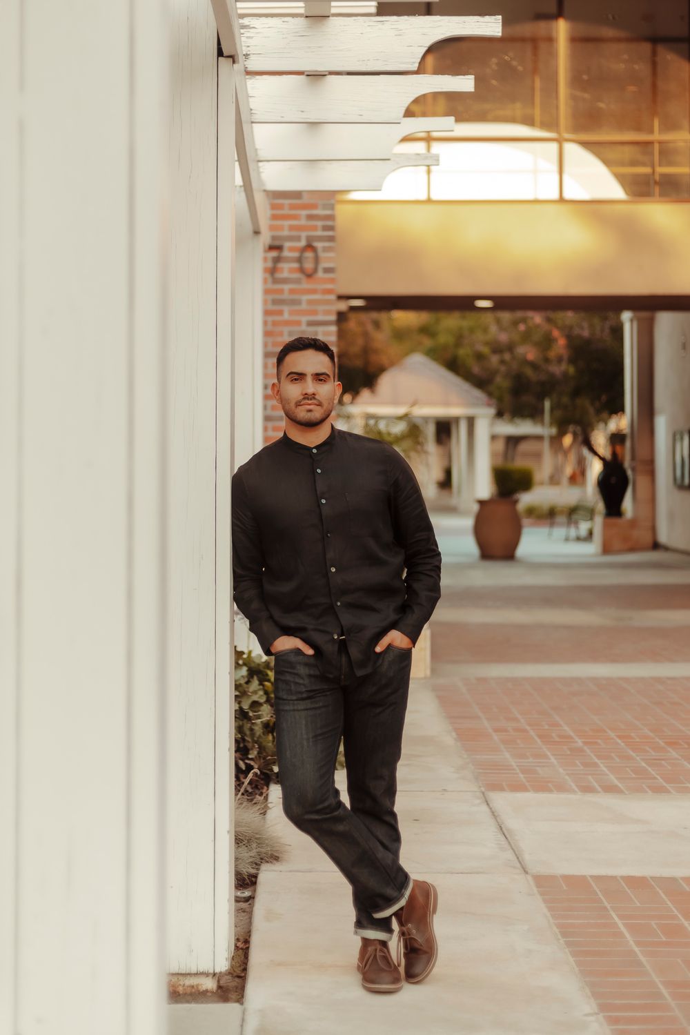 Man in a black button-down shirt and dark jeans posing for his headshots in Irvine California