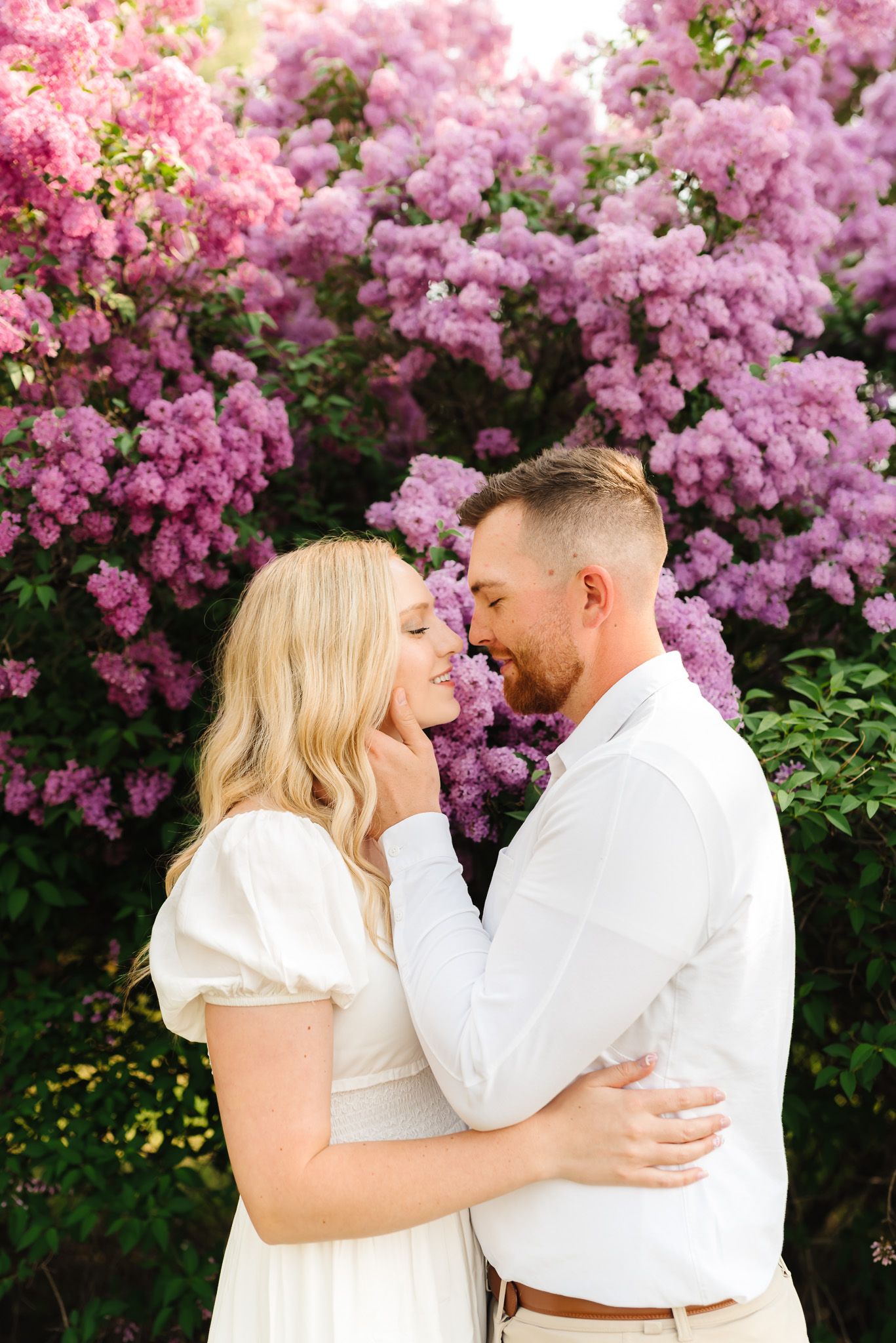 Romantic portrait against a blooming pink cherry blossom tree in springtime.