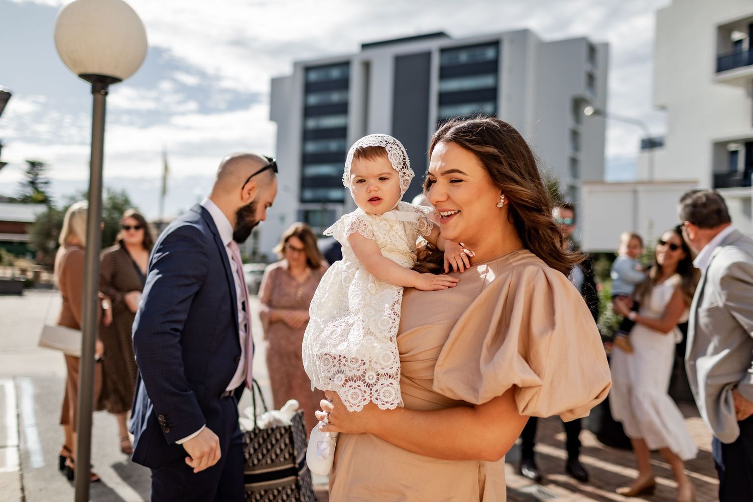 A celebration gathering outdoors with people dressed in formal attire.