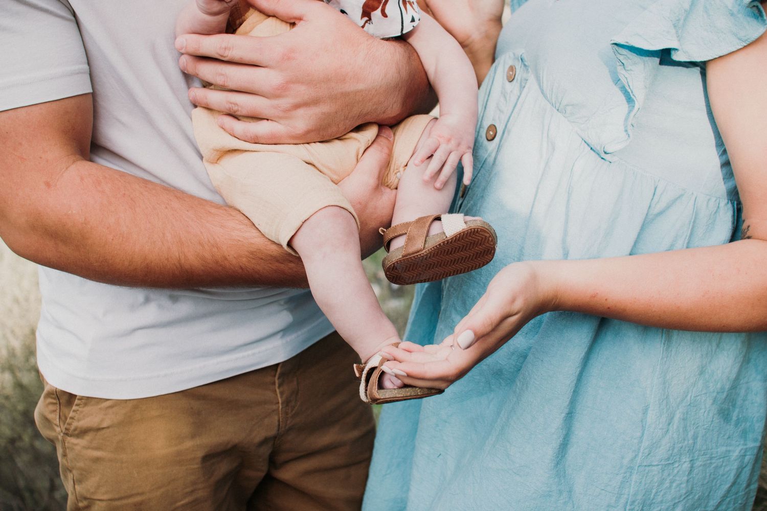 Tender moments shared between parent and newborn baby in soft pastel tones.