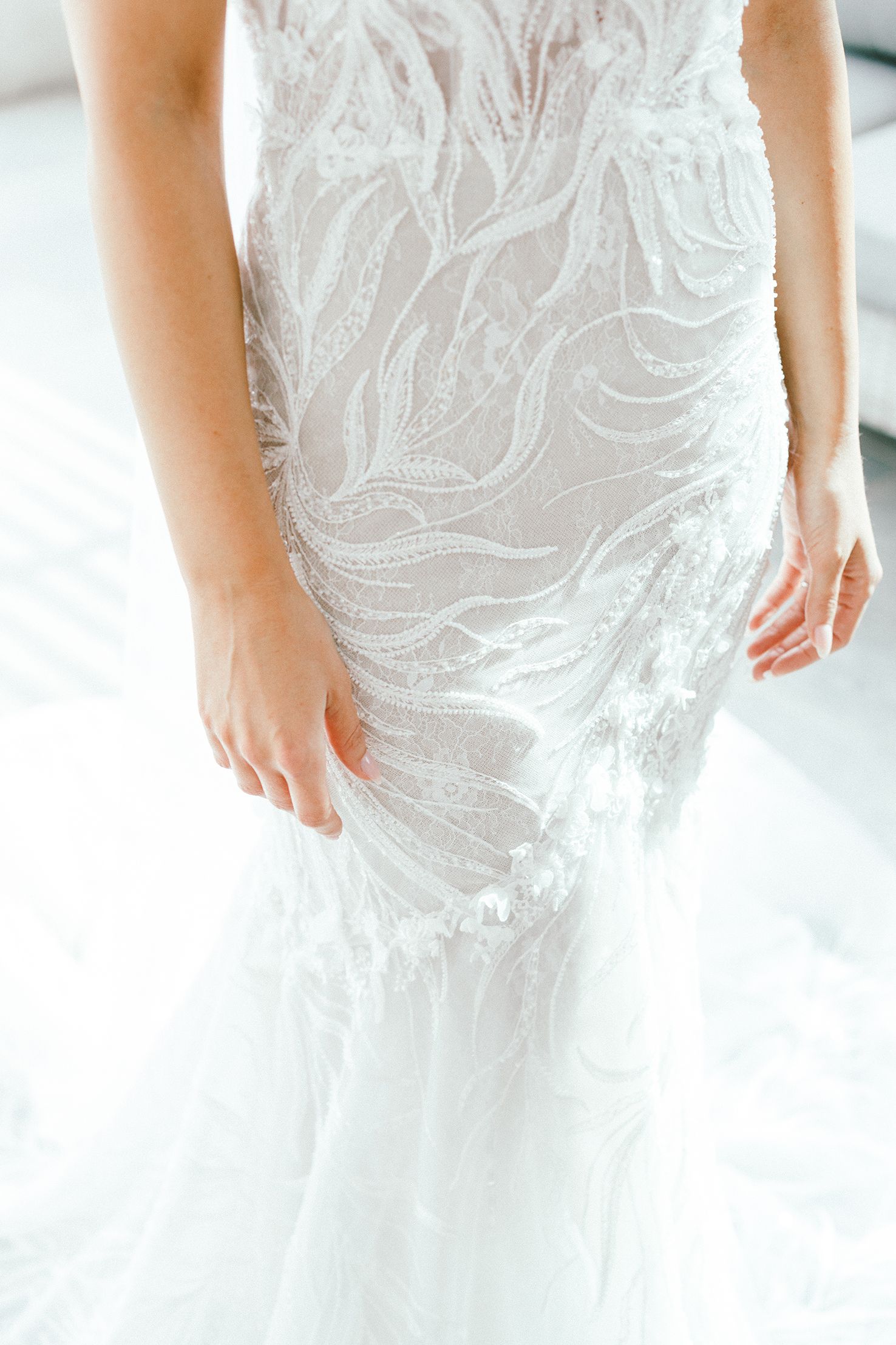 White wedding dress with delicate embroidered patterns shown in detail.