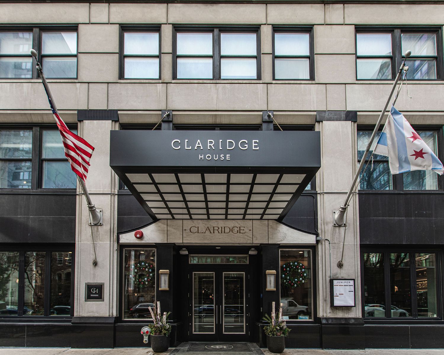 Exterior entrance of the Claridge building with American flags and modern architecture.
