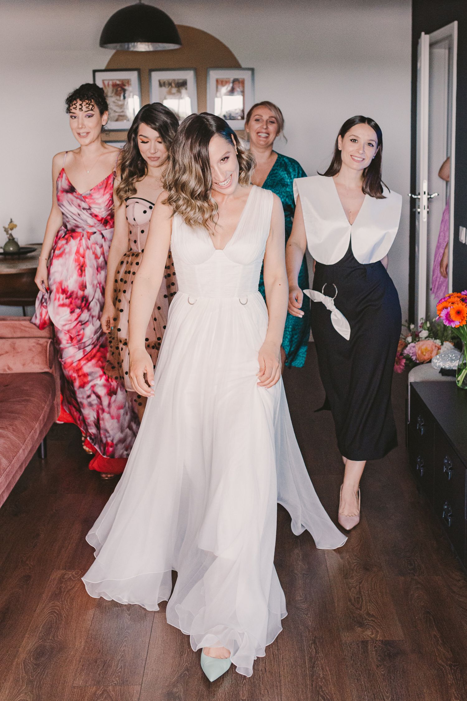 Wedding guests dance and celebrate on a wooden floor during a reception party.