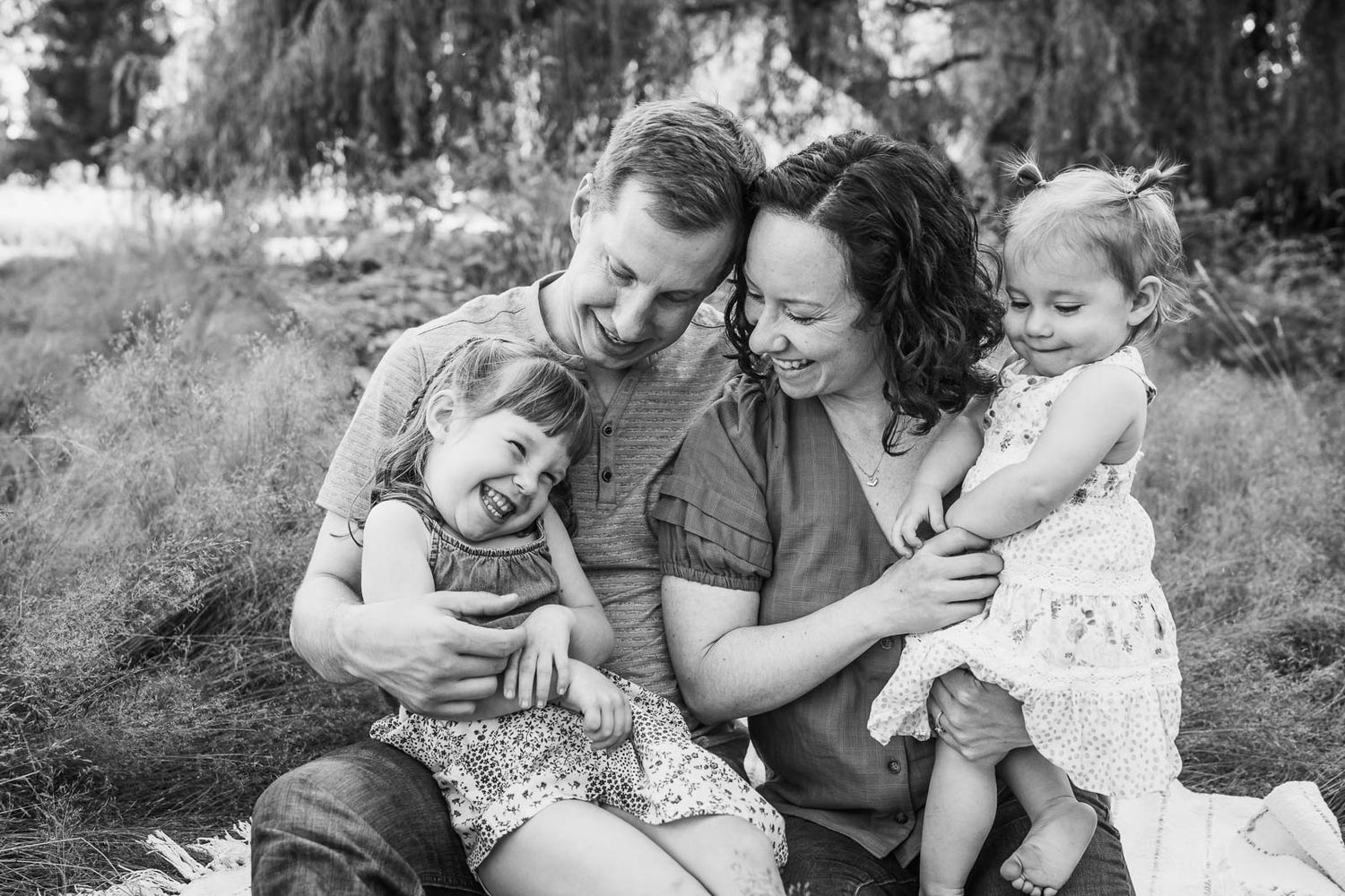 Family tickling their children in an outdoor family photo session.