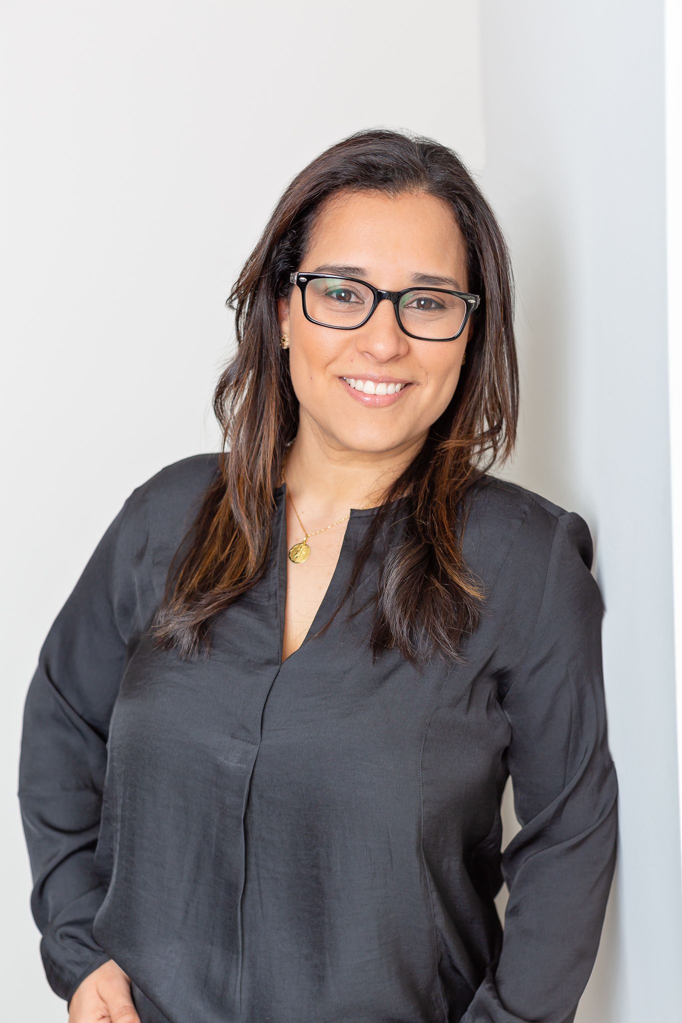 Professional headshots against white background wearing black top and glasses.
Personal branding.
