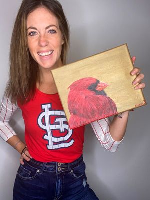 Red cardinal bird painting on metallic gold canvas background.