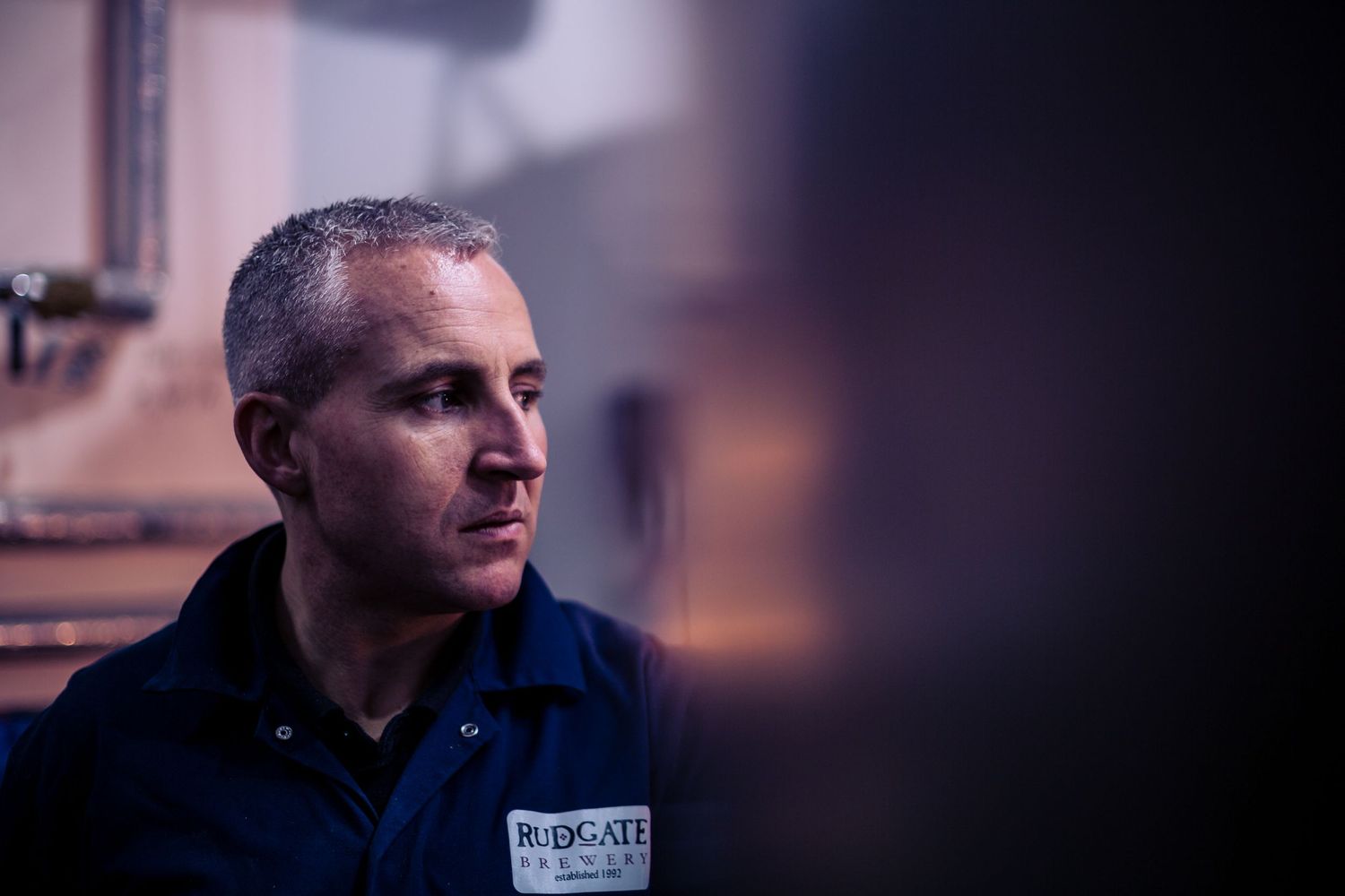 Professional in navy blue uniform photographed in dim lighting with soft focus background.