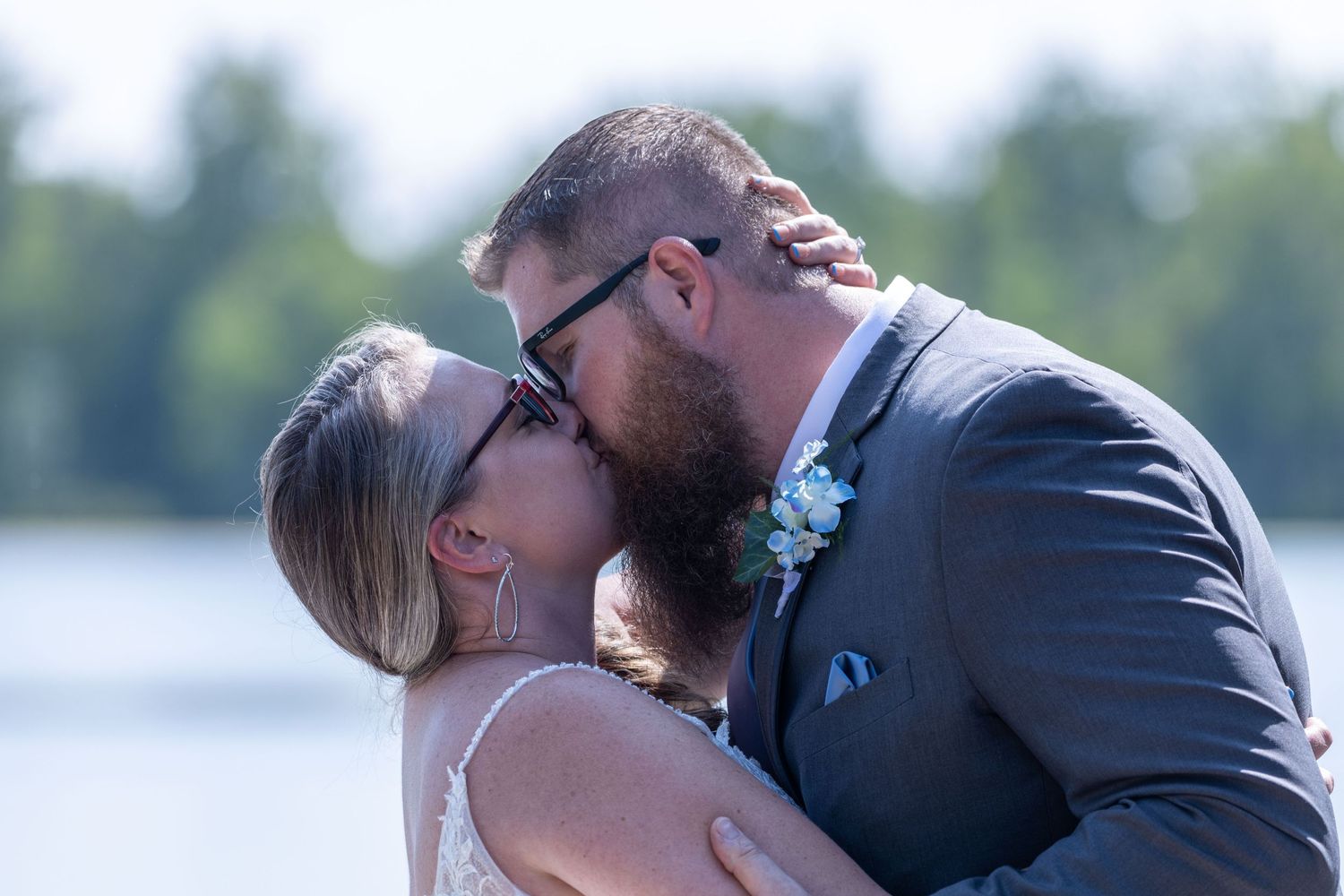 Couple sharing an intimate moment against a lakeside backdrop.