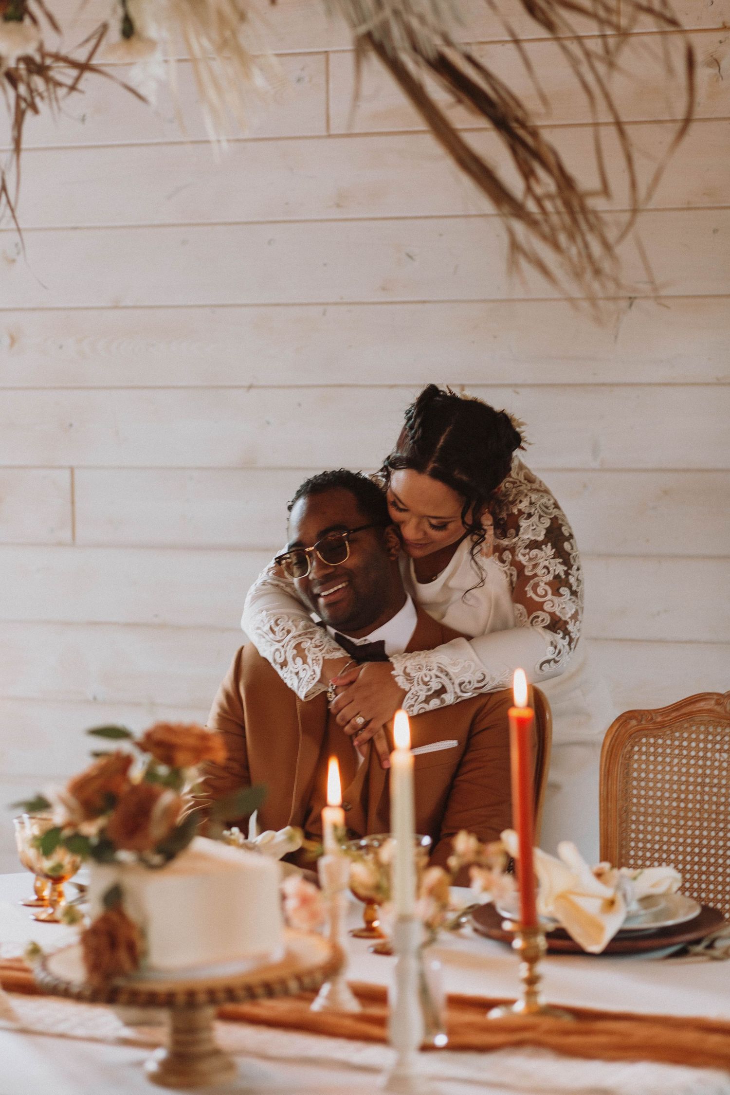 Wedding couple snuggles at the dinner table at Maidenwood Weddings and Events in Stockholm, Wisconsin