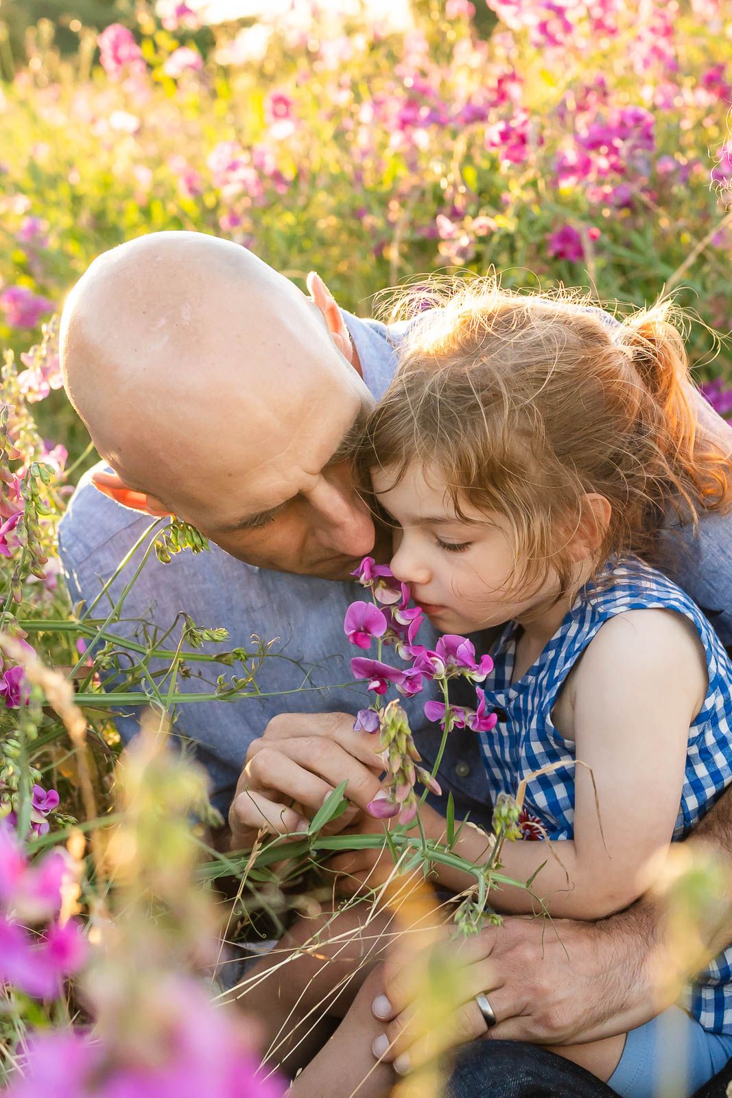 Father and daughter smelling the sweet pea flowers in Seattle.