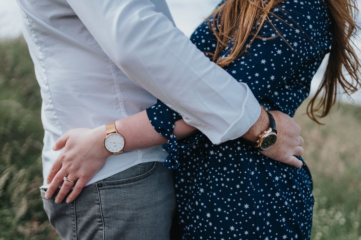 a close up of a couple with their hands round each eachothers waist