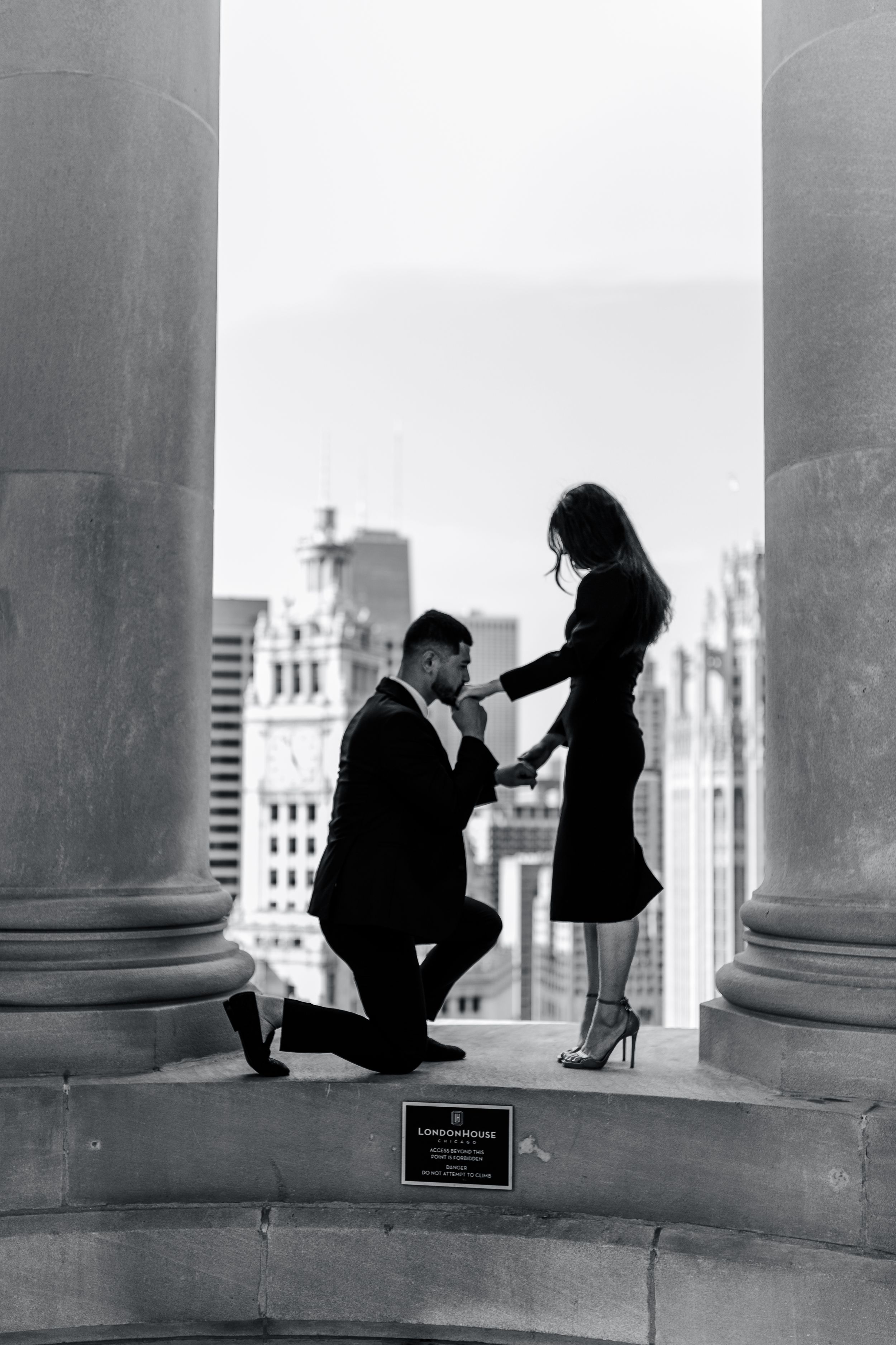 Romantic proposal silhouette between urban building columns.