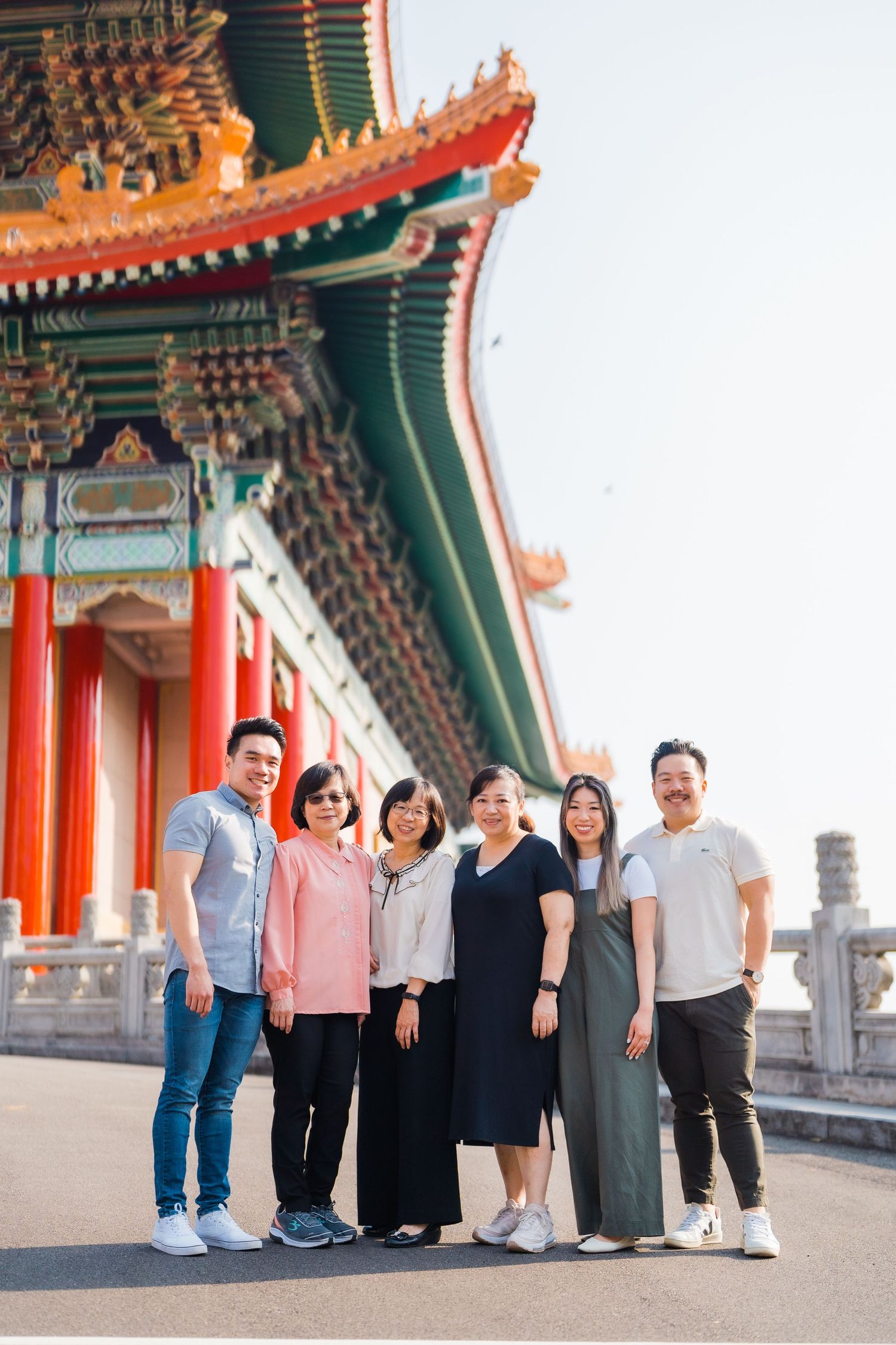 Group poses together in front of ornate traditional Chinese temple architecture.