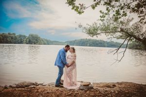 A tender moment between a couple on a lakeside beach during a photo session.
