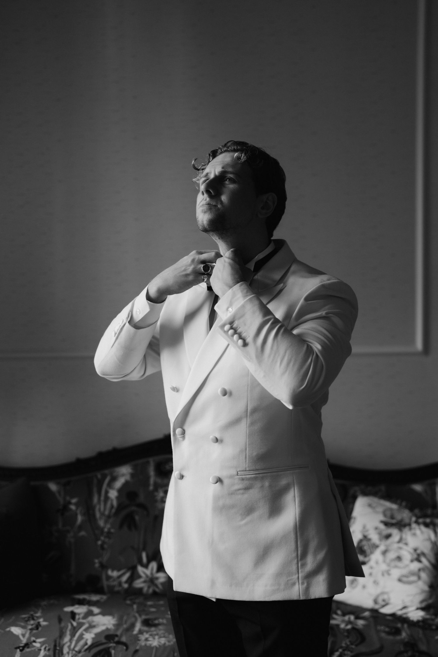 groom fastening his bow tie at the Randolph hotel in oxford