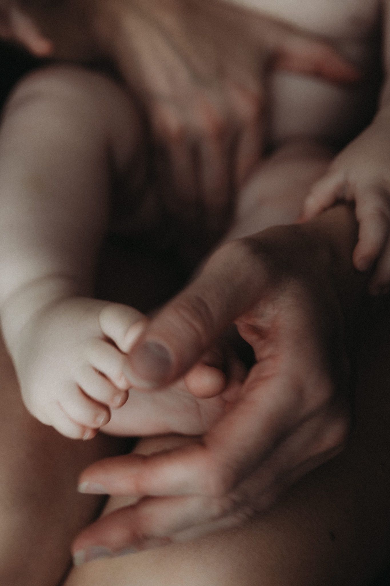 Close-up of a baby’s hand gently holding an adult’s finger.