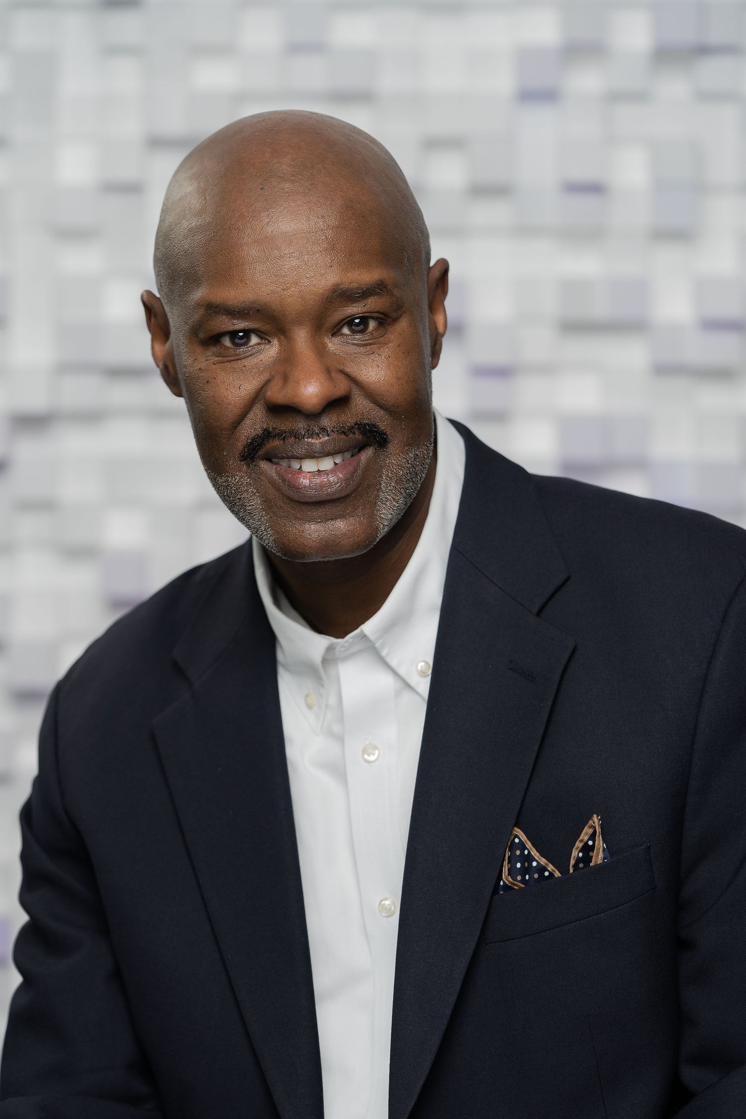 Professional headshot of a confident executive wearing a tailored suit