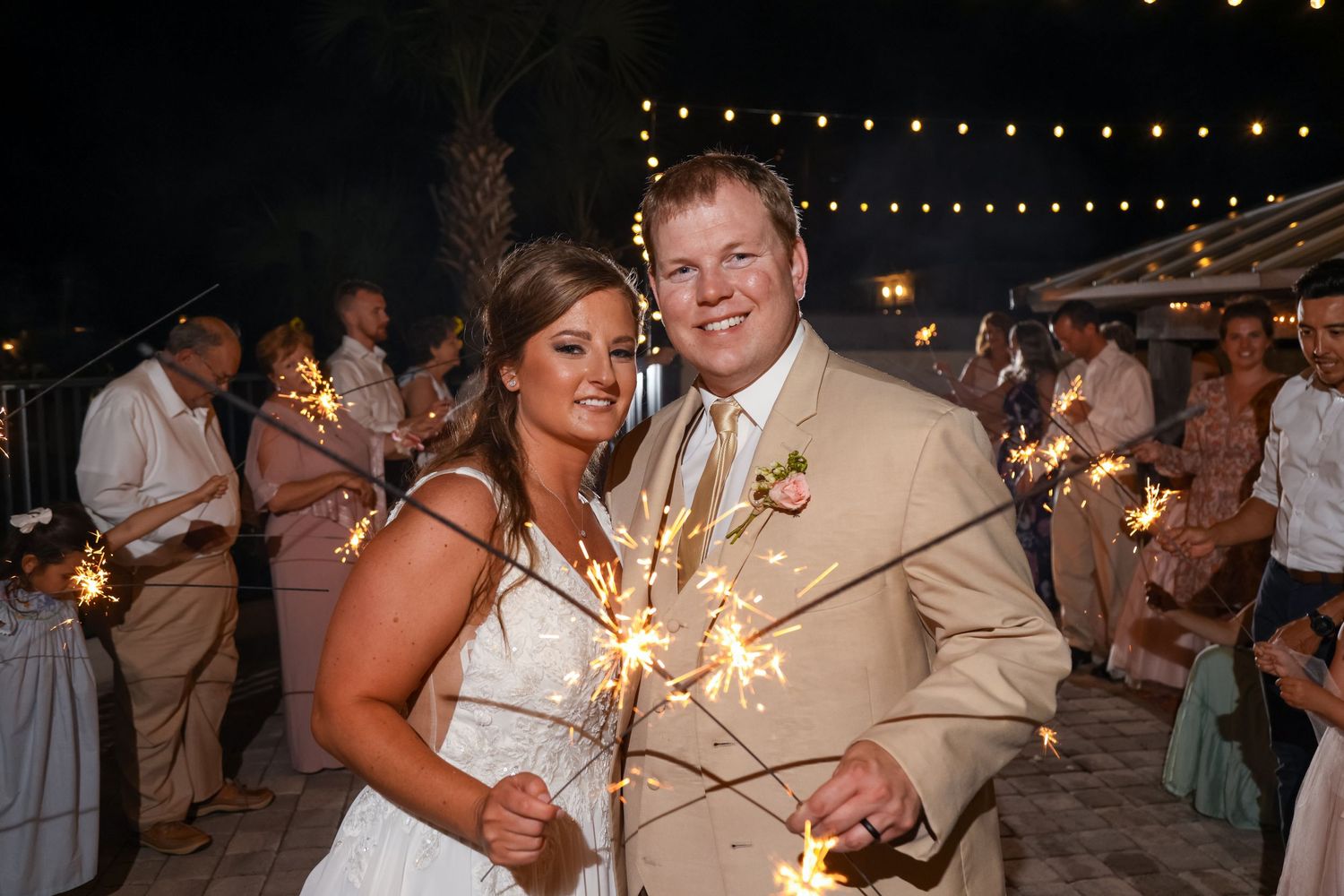 Couple celebrates with sparklers during their evening wedding reception.