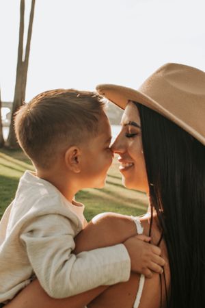 Intimate family moment captured in warm sunlight between palm trees.