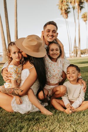 Natural light family photography session with palm trees and laughter.