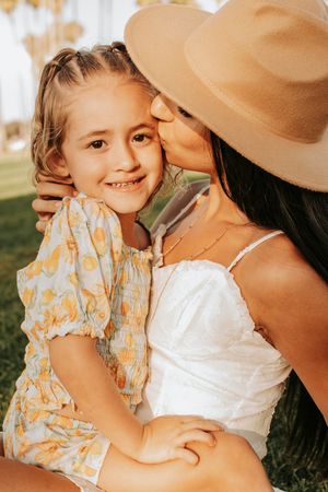 Close-up tender moments during sunset family photoshoot in tropical setting.