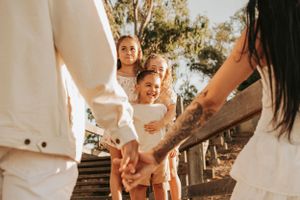 Candid family moment captured on wooden stairs during golden hour photoshoot.