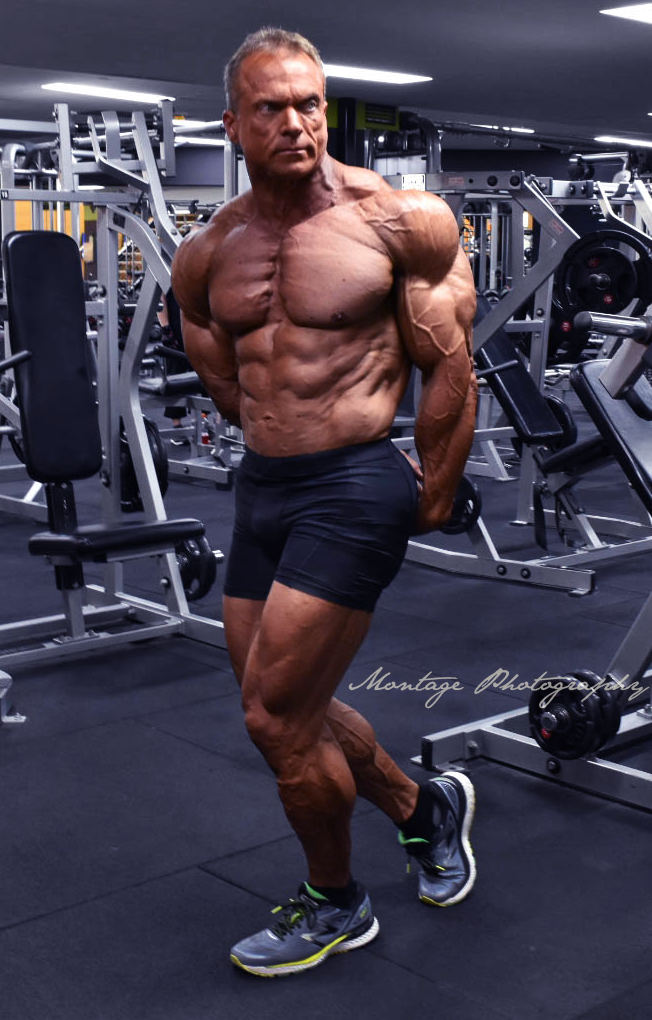 Professional bodybuilder showing muscular physique in modern gym environment.