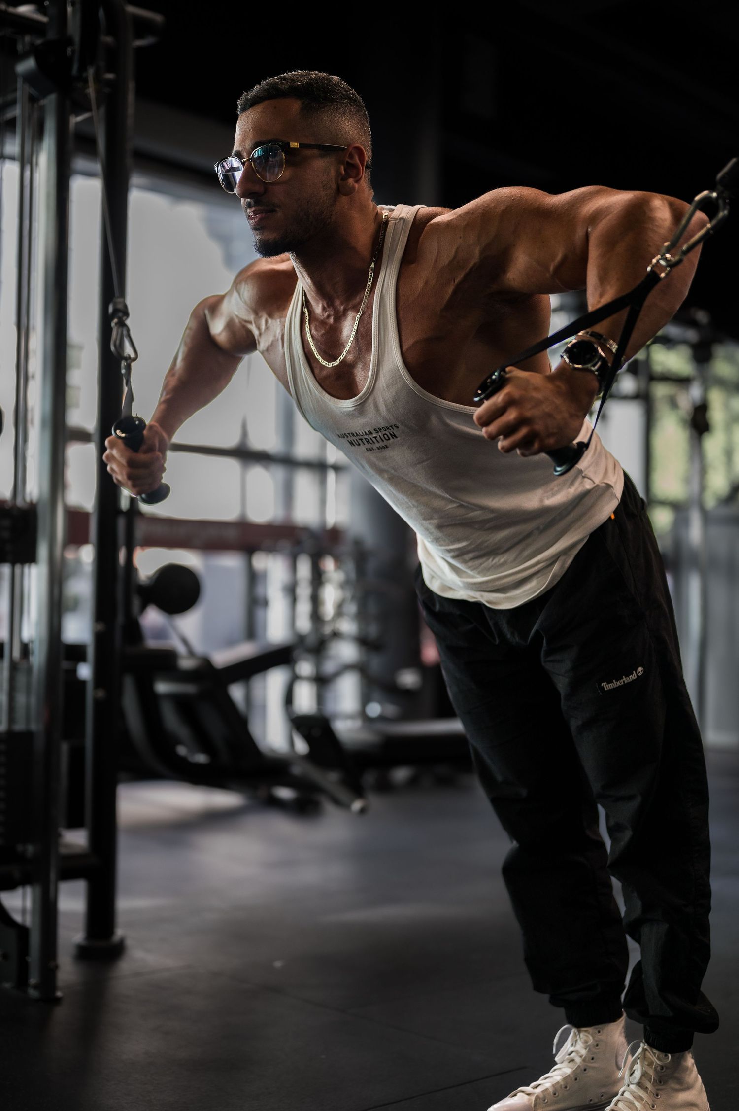 Athlete performing cable machine exercise in a modern gym setting.